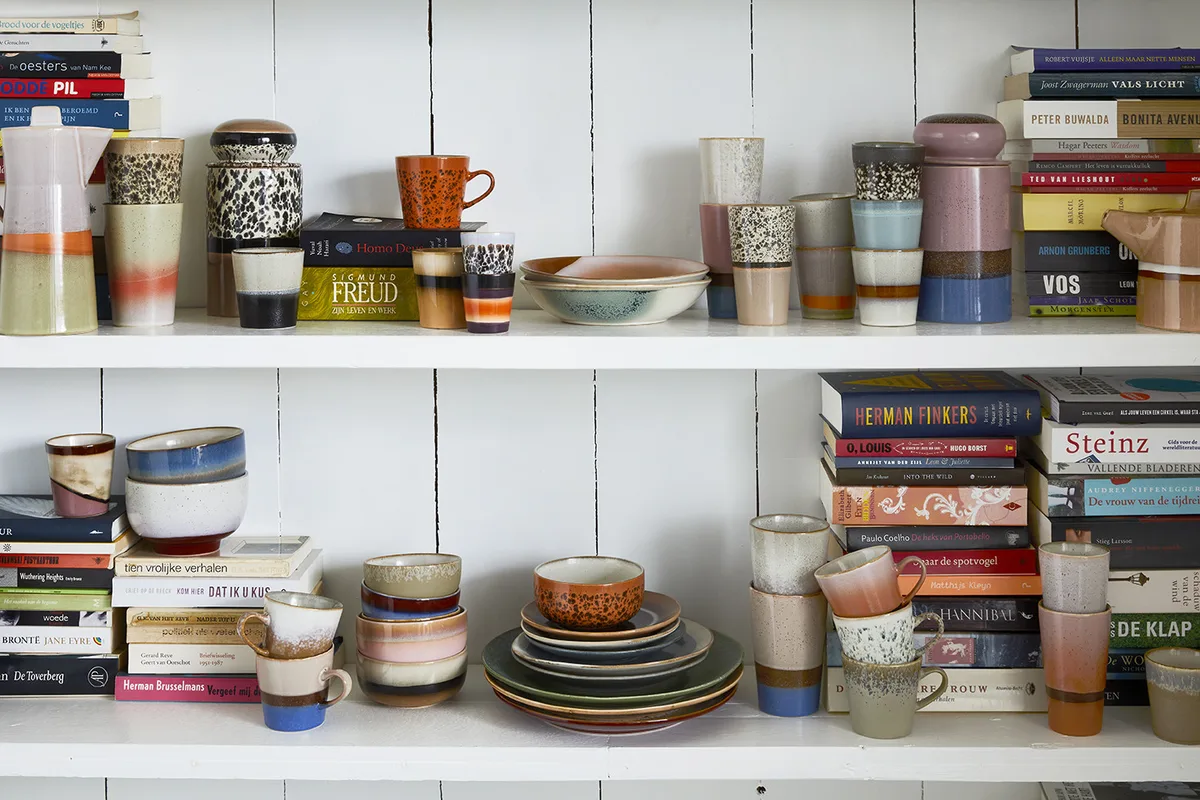 Open kast met keramiek, boeken en kleuraccenten