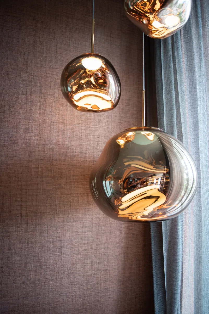 Twee gouden hanglampen voor een wand met fijne textuur